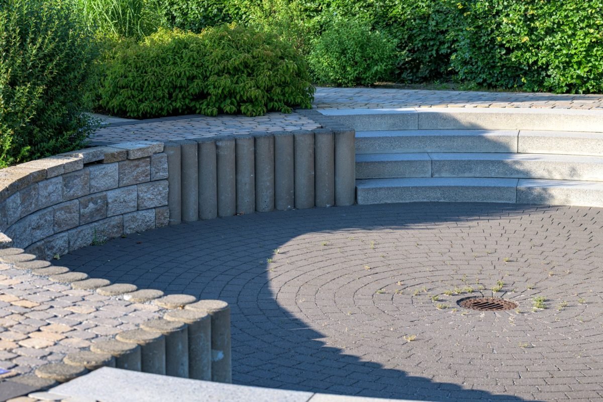 Circular stone patio with steps in a landscaped garden